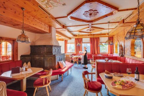 un restaurant avec une cheminée, des tables et des chaises dans l'établissement Apparthotel Talhof, Restaurant, Pool und Spa, à Oberau