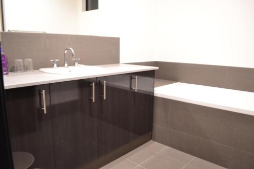 een badkamer met een wastafel en een spiegel bij Perth Urban Lodge in Perth