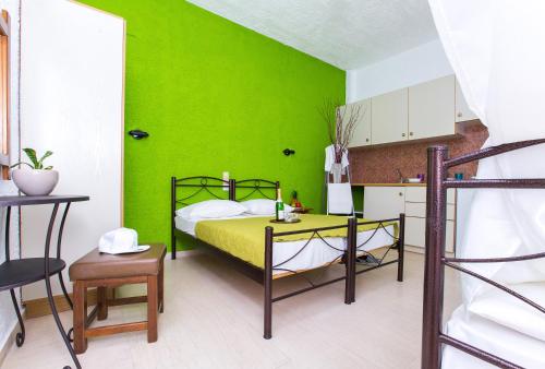 a green bedroom with a bed and a table at Litsa Studios in Malia