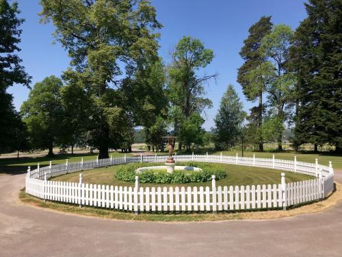 a white fence around a park with a fountain at Gylleby Vandrarhem in Sunne