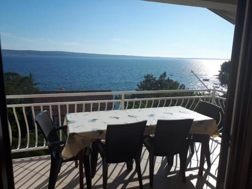 a table and chairs on a balcony with a view of the ocean at Apartments Ivanka in Starigrad