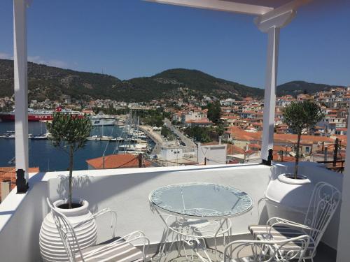 a balcony with a table and chairs and a harbor at Gigi Rooms in Poros