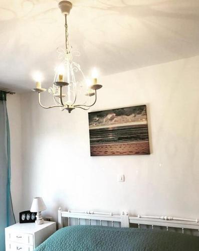 a bedroom with a green bed and a chandelier at Faros oasis in Gdinj
