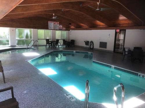 a large swimming pool in a room with tables and chairs at The Landing Resort in Egg Harbor
