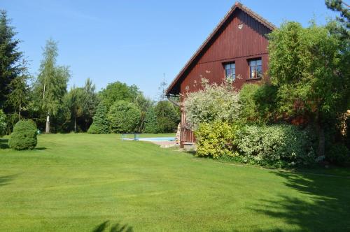 a red barn with a green yard in front of it at Penzion 409 in Horní Branná