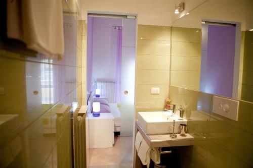 ein Bad mit einem Waschbecken und einem Spiegel in der Unterkunft As Easy in Assisi