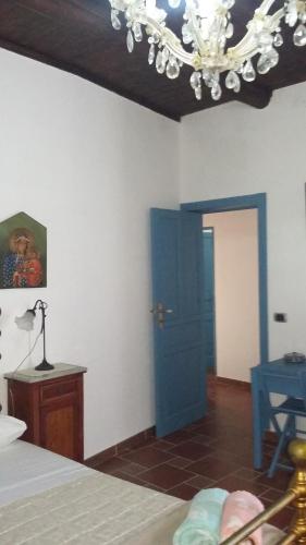 a bedroom with a blue door and a chandelier at B&b Lemon Garden in Sciacca