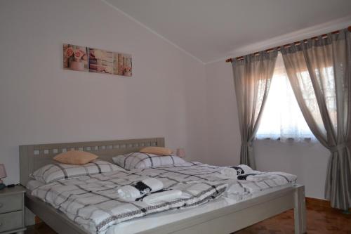 a bedroom with a bed with pillows and a window at Apartman Ika Umag in Umag
