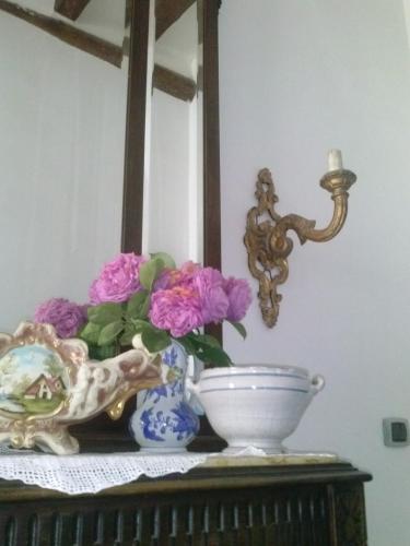 a table with flowers in a blue vase and a mirror at B&b Lemon Garden in Sciacca