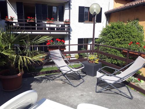 two chairs on a patio with flowers and a balcony at Da Mara Lago Di Como in Sormano