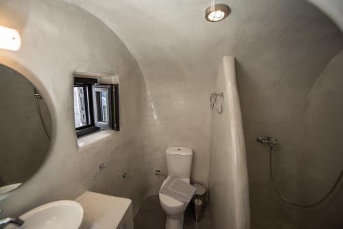 a bathroom with a sink and a toilet and a mirror at Caves 1880 in Oia