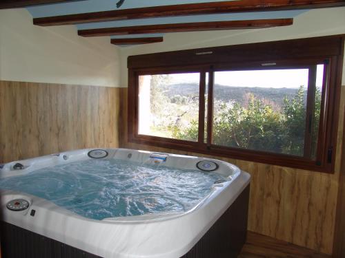 bañera grande en una habitación con ventana en Apartamentos Casa Sanz en Asque