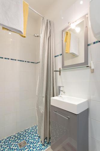 a white bathroom with a sink and a shower at Studio Meublé in Gentilly