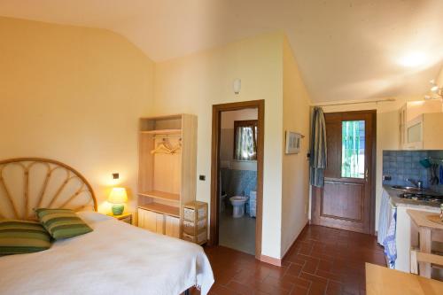 a bedroom with a bed and a bathroom with a toilet at Agriturismo Sicomoro in Capalbio