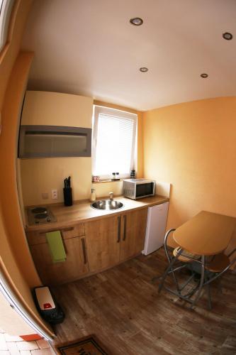 a small kitchen with a sink and a microwave at Apartmány Dimitra in Štúrovo