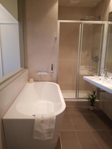 a white bathroom with a tub and a sink at Riva Palace in Split