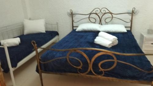 a bedroom with two beds with blue sheets and white pillows at Εmmi in Koutsounari