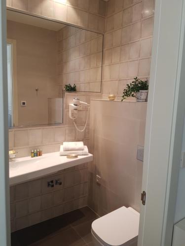 a bathroom with a sink and a toilet and a mirror at Riva Palace in Split