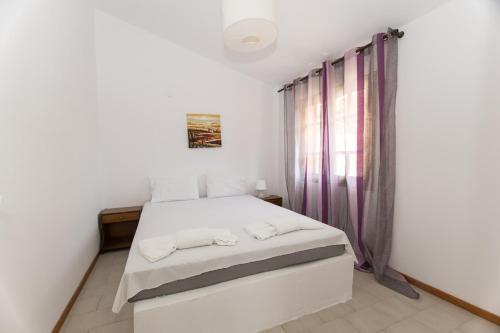 a bedroom with a white bed and a window at Katerina's Garden Mola Kaliva in Mola Kalyva