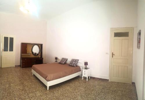 a bedroom with a bed and a mirror and a door at Dai nonni in Niscemi