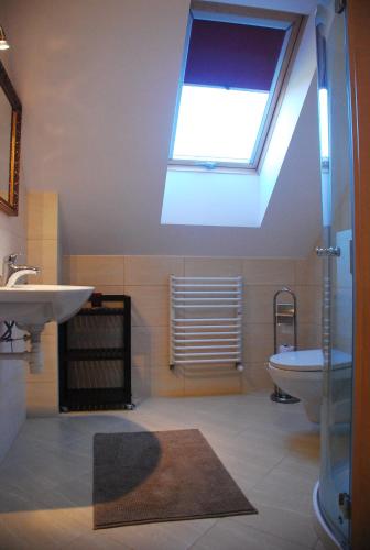 a bathroom with a window and a sink and a toilet at Apartamenty ANNA in Brenna