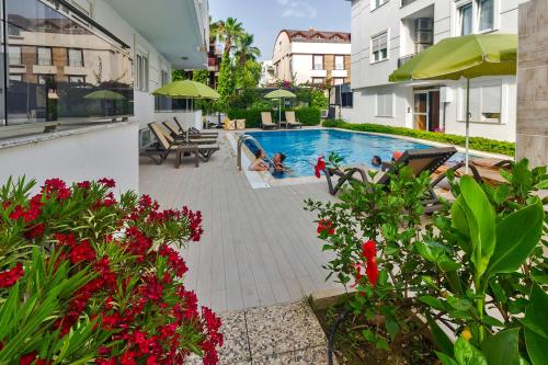 a swimming pool in the middle of a building with flowers at Aspendos Seaside in Antalya