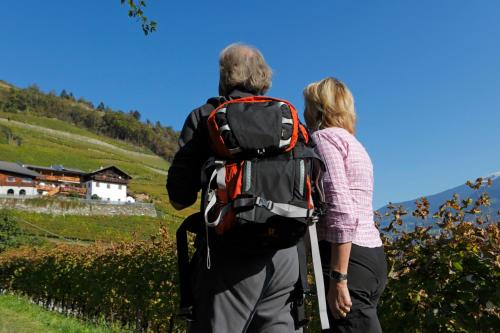 a man and woman standing on a hill with a backpack at Hofer Hof in Feldthurns
