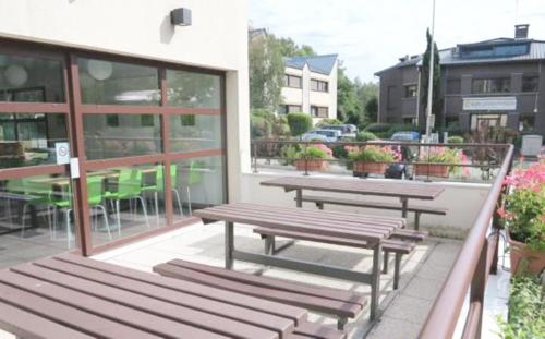 two wooden benches sitting on a balcony of a building at Ibis Budget Grenoble Sud Seyssins in Seyssins