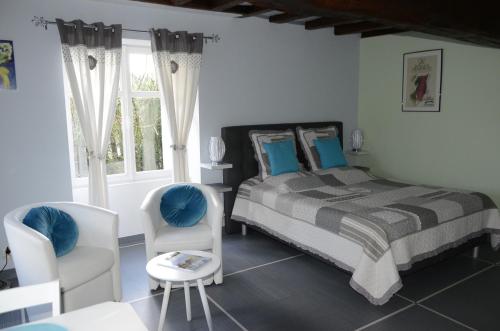 um quarto com uma cama, 2 cadeiras e uma mesa em Domaine De Meigne em Meigné