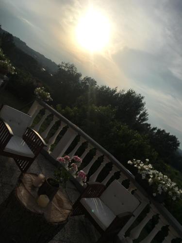 a bench with flowers and the sun in the sky at Rossella alla Villarella dei Tulipani in Asti