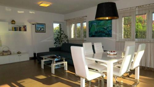 a living room with a table and white chairs at House Mia in Ližnjan