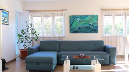 a living room with a blue couch and a table at House Mia in Ližnjan