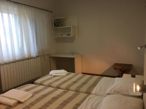 a bedroom with two beds and a table and a window at House Mia in Ližnjan