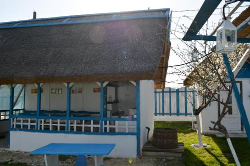a blue and white house with a thatched roof at Sailors Guest House Jurilovca in Jurilovca