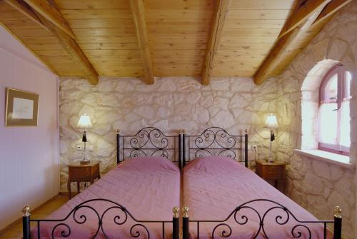 a bed in a bedroom with a wooden ceiling at Aresti Mountain Resort in Agios Leon