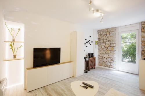 トゥーロンにあるGregBnb-com - Studio CLIMATISÉ - Terrasse & parking privéの白い壁のリビングルーム(テレビ付)