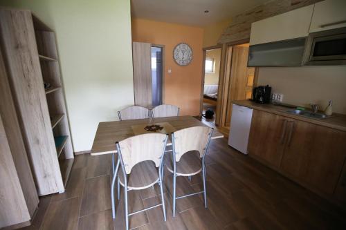a kitchen with a table and chairs in a room at Apartmány Dimitra in Štúrovo
