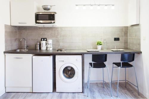 a kitchen with a washer and dryer under a counter at GregBnb - Studio moderne - Coin nuit - CLIMATISÉ in Toulon