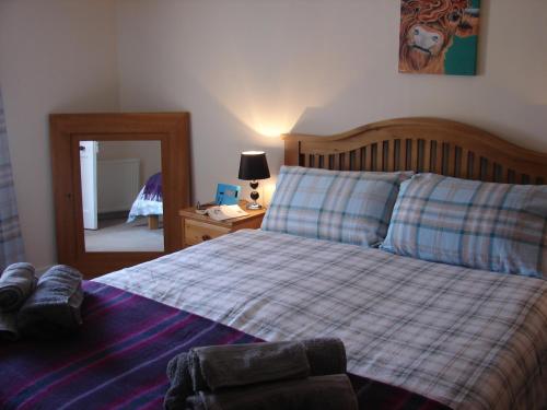 クロマーティにあるAnchorageのベッドルーム1室(ベッド1台、プライド毛布、鏡付)