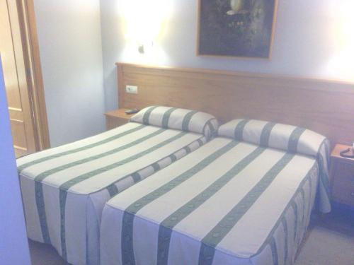 a bedroom with two beds with striped sheets at Hotel Goya in Seville
