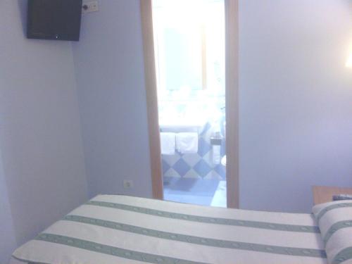 a bedroom with a bed and a large mirror at Hotel Goya in Seville
