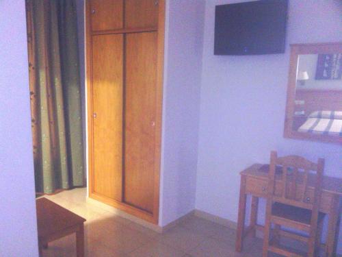 a dining room with a wooden cabinet and a table at Hotel Goya in Seville