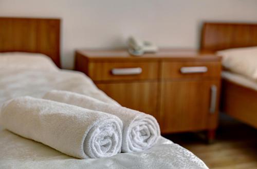 two towels on a bed in a hotel room at Penzion Tillerova vila in Lázně Bohdaneč