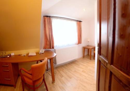 a small room with a desk and a window at Penzion Tillerova vila in Lázně Bohdaneč