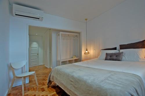 a bedroom with a large bed and a chair at Downtown Cathedral Apartment in Braga