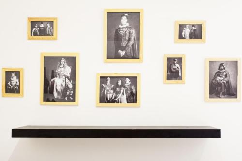 un mur avec des photographies encadrées sur un mur blanc dans l'établissement GregBnb - Studio Cosy - CLIMATISÉ - WIFI - 15min Gare, à Toulon