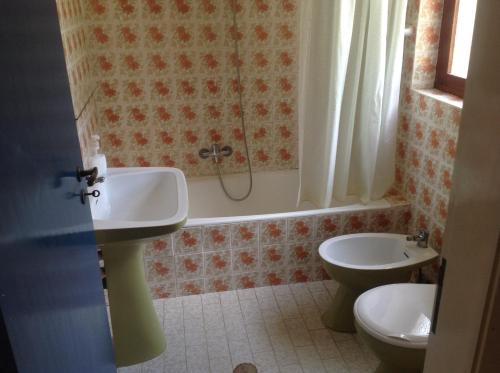 a bathroom with a sink and a toilet at Quinta do Atlantico in Santa Bárbara de Nexe