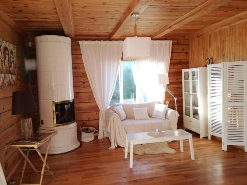 a living room with a white couch and a window at Lakeshore house in Dvarčėnai