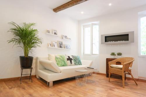 a living room with a white couch and a chair at GregBnb-com - T2 Cosy et design - PARKING INCLUS - WiFi - 15min Gare in Toulon