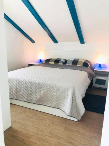 a bedroom with a bed with two lights on it at Apartments Bakula in Mandre